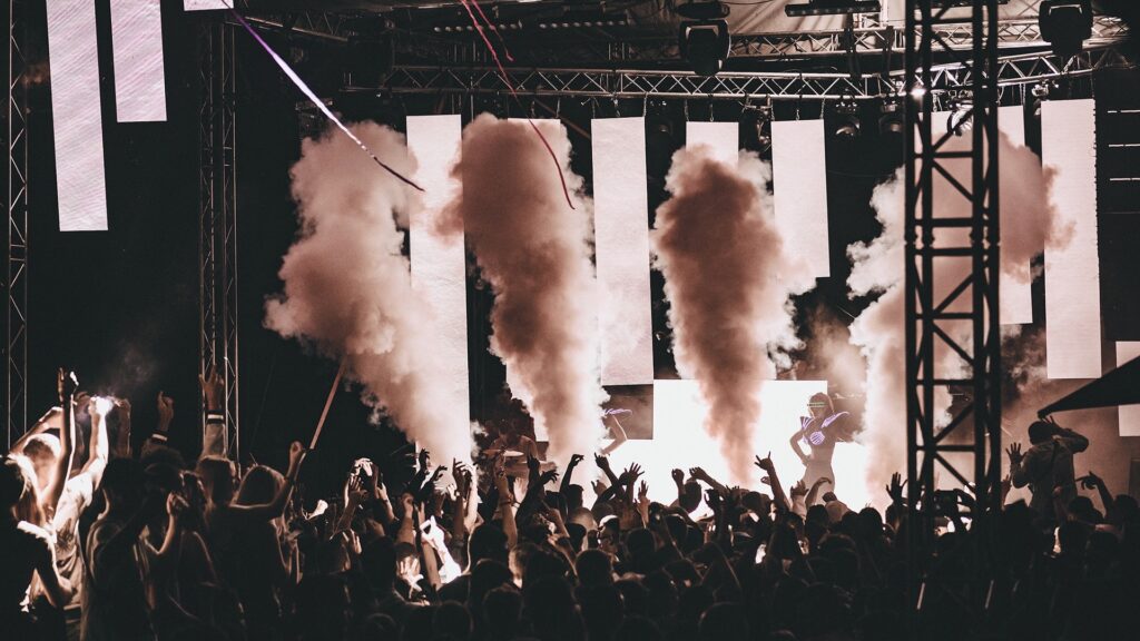 Ein Nachtclub mit tanzenden Menschen und Rauch.