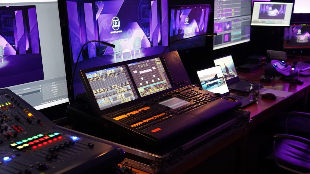 Aufnahmestudio mit mehreren Bildschirmen und Geräten.