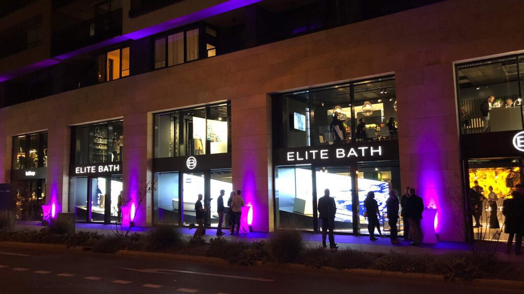 Shop Elite Bath bei Nacht mit Menschen beleuchtet