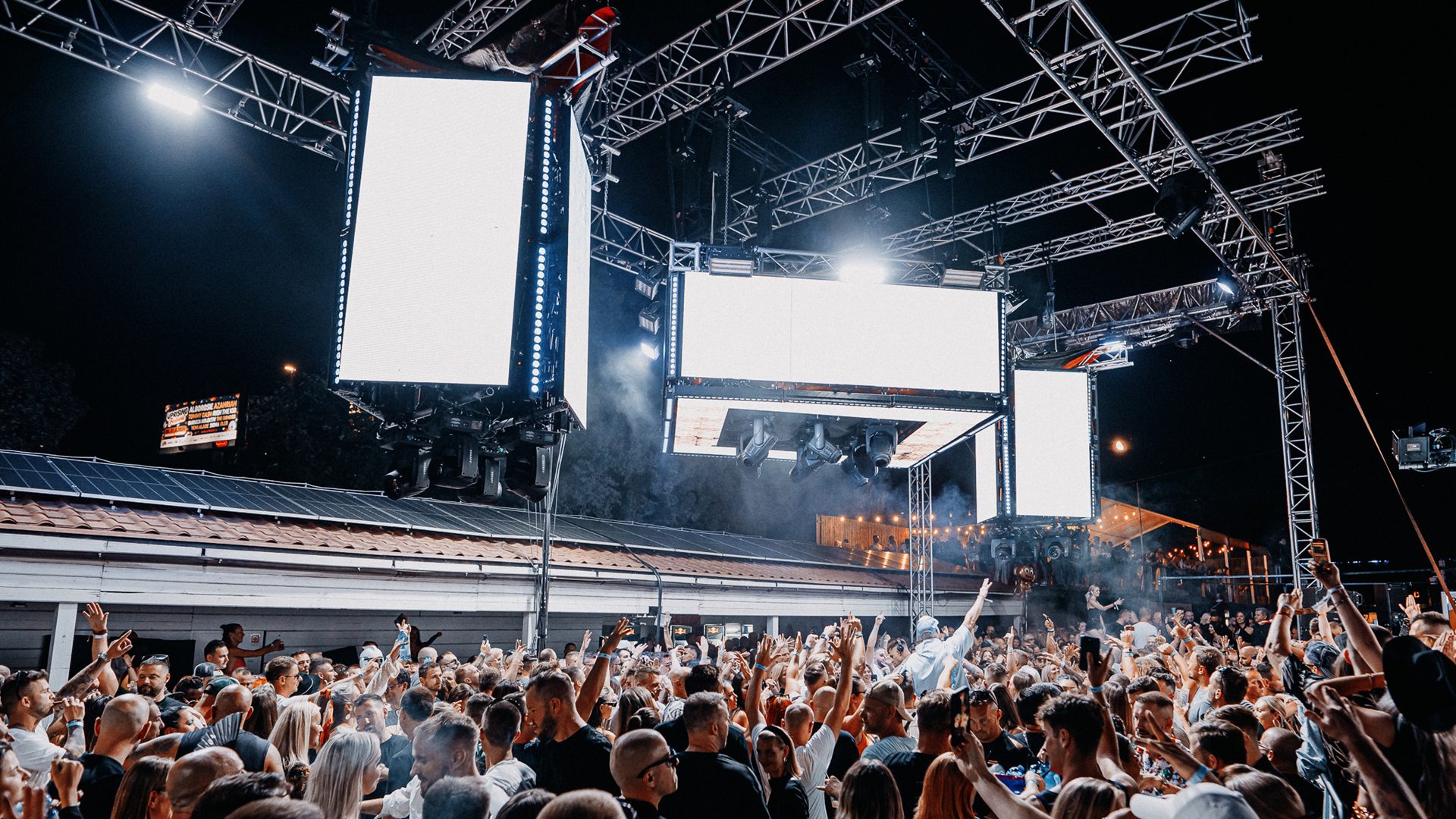 Massenhaftes Nachtkonzert unter freiem Himmel mit vielen lustigen Leuten.