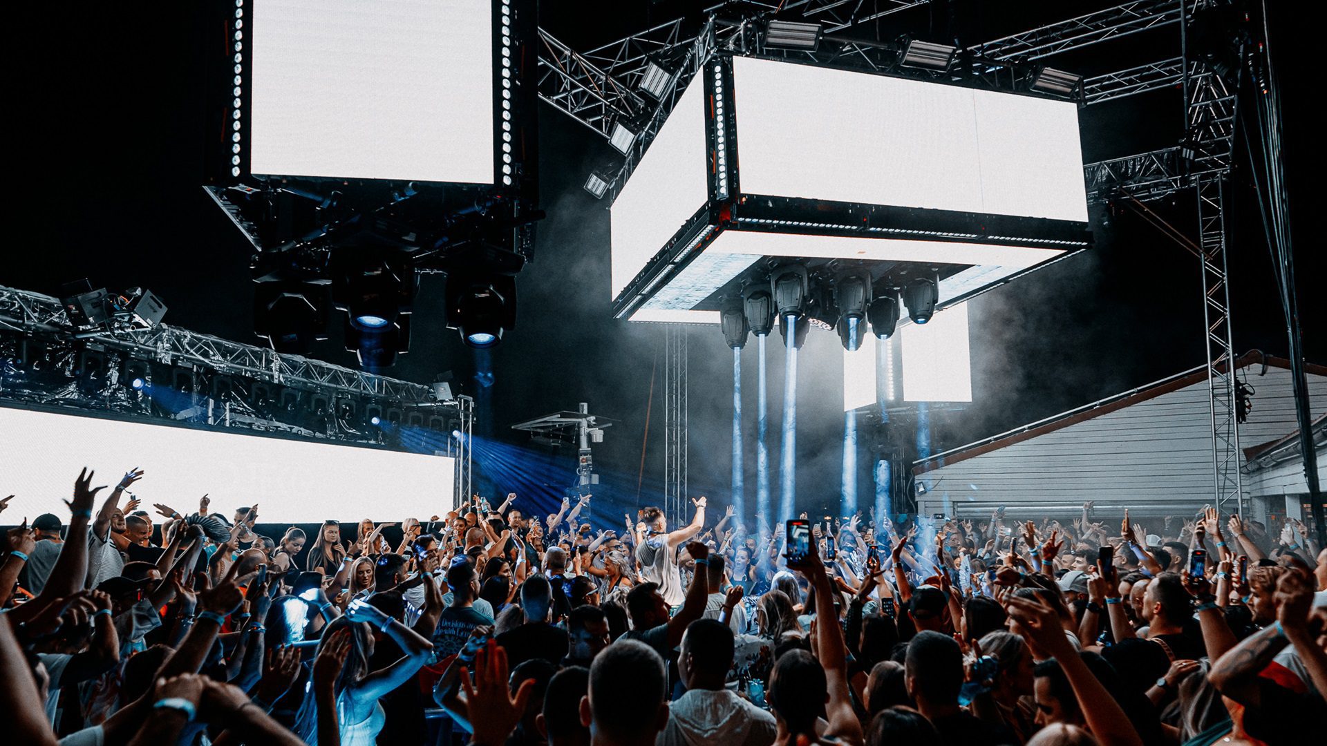 Tanzende Menschenmenge auf einem Musikfestival mit Neonlicht