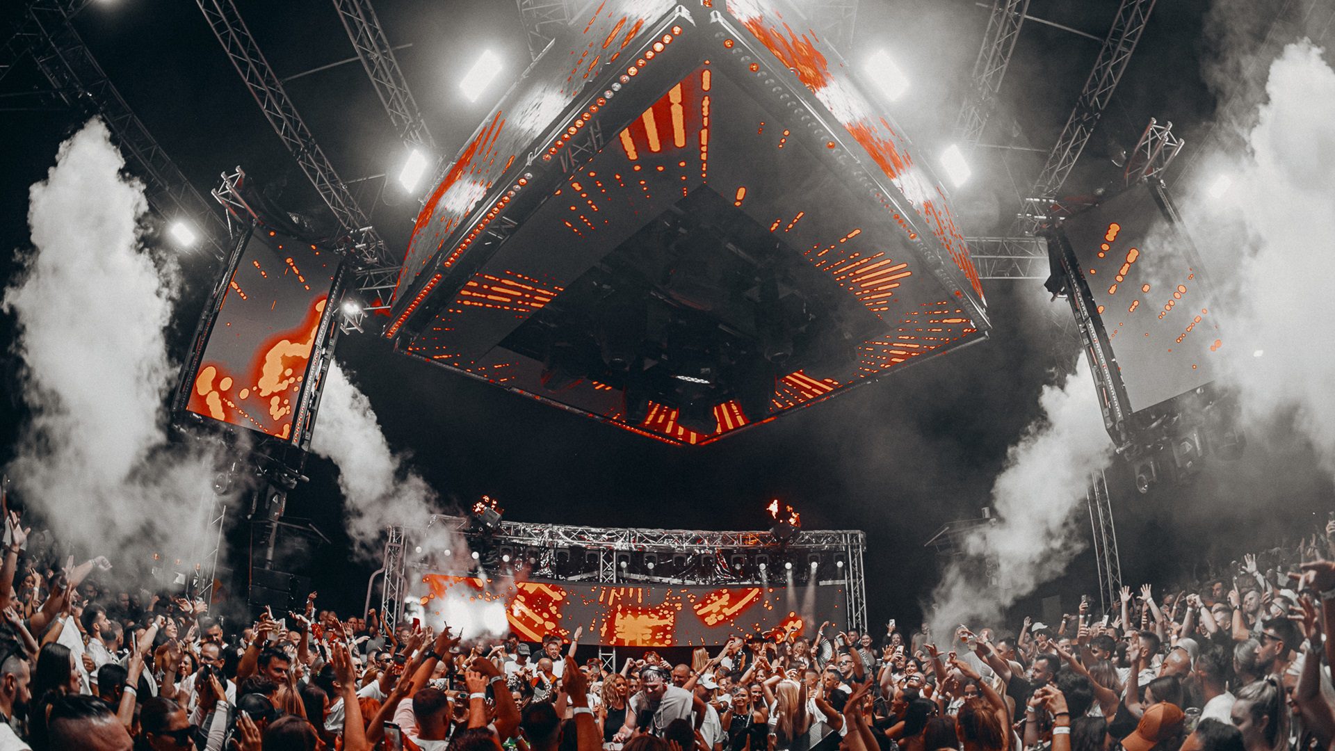 Eine große Tanzparty mit Lichtern und einer Menschenmenge.