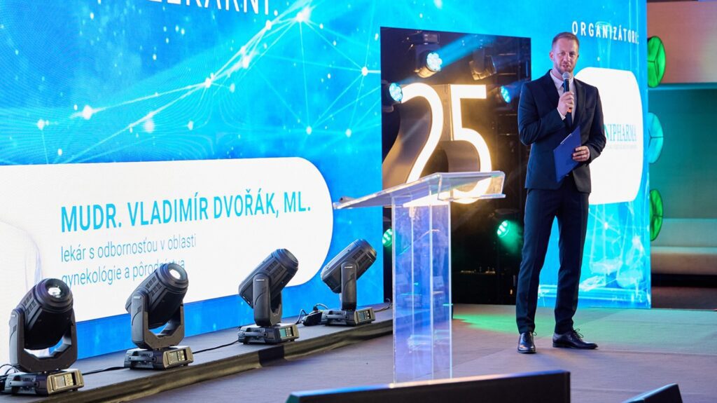 Eine Person spricht auf einer Bühne mit Beleuchtung.