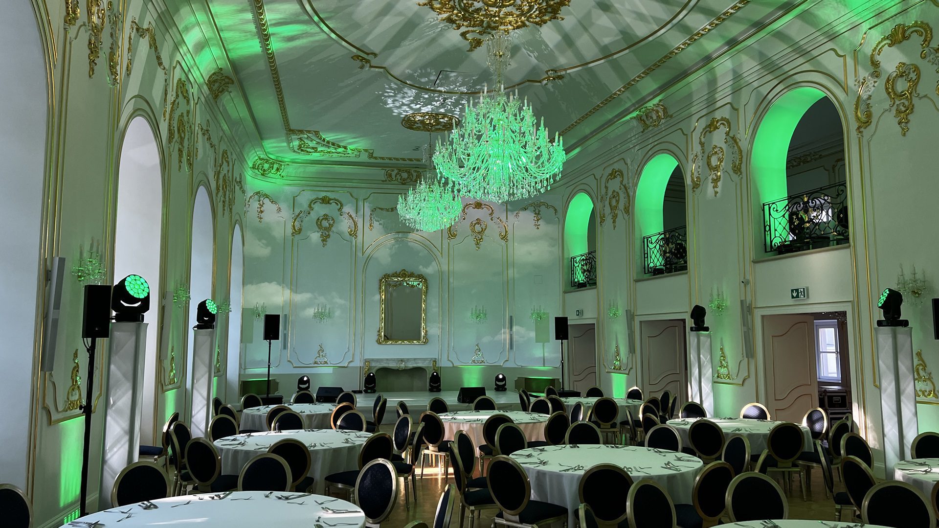 Starožitná banketová sála so zeleným osvetlením.