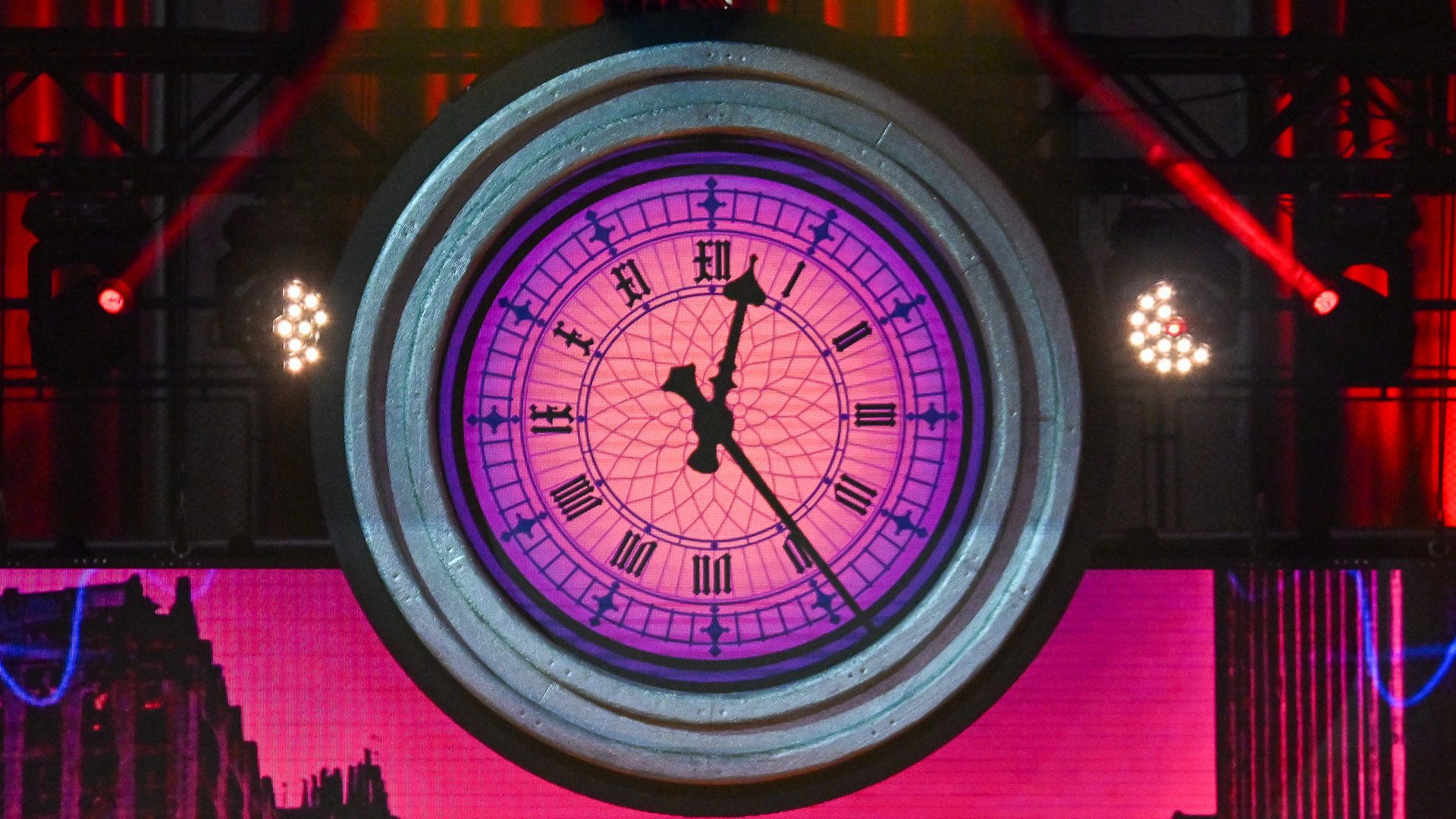 Beleuchtete Uhr auf dem bunten Gebäude am Abend