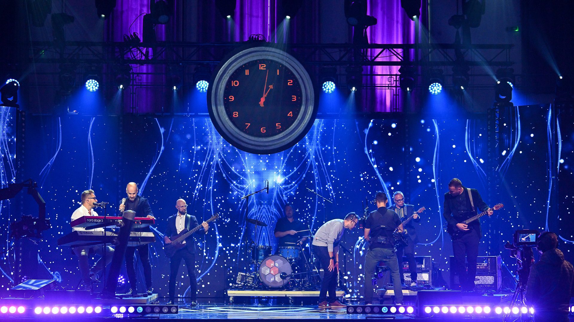 Die Band tritt auf der Konzertbühne mit einer Uhr auf.