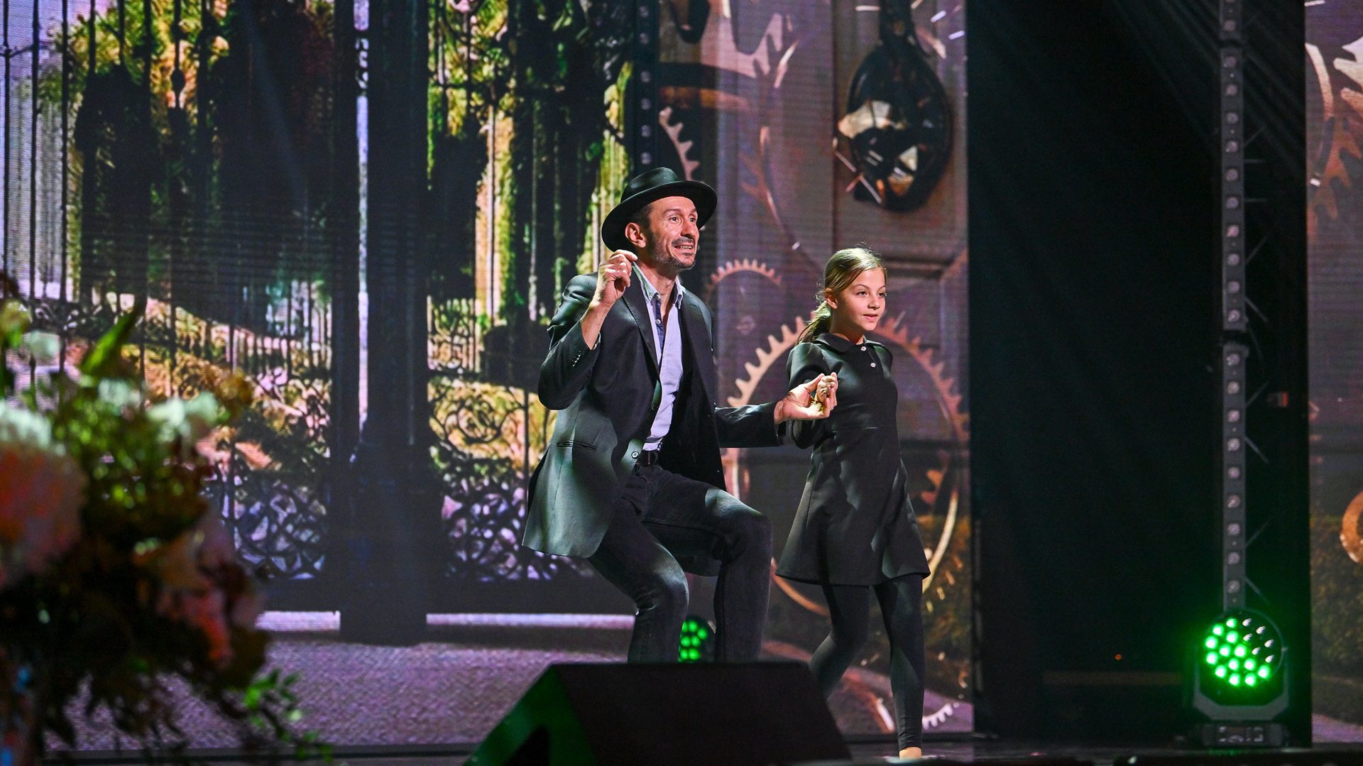 Tanzvorführung eines Paares auf der Bühne mit Blumen