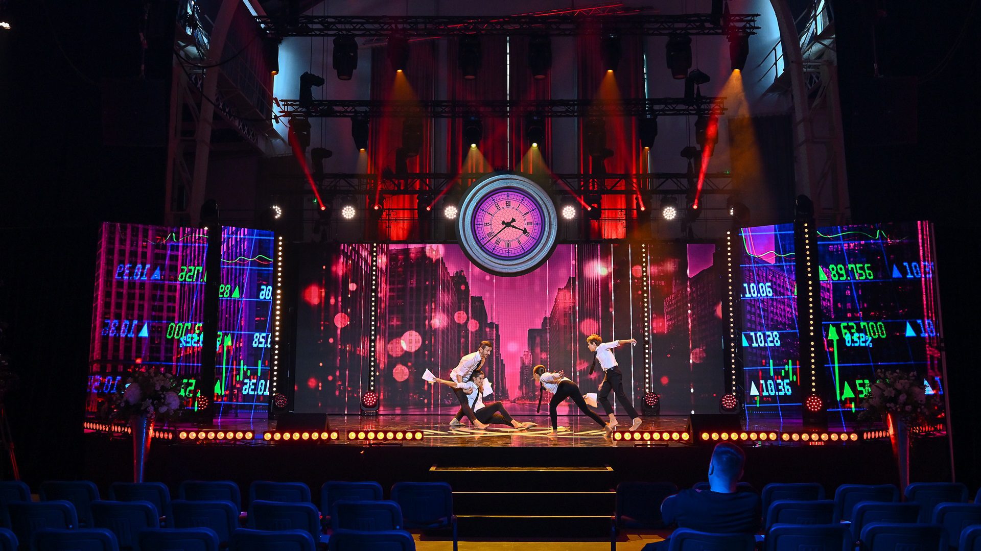 Tanzen auf der Bühne mit farbiger Hintergrundbeleuchtung.