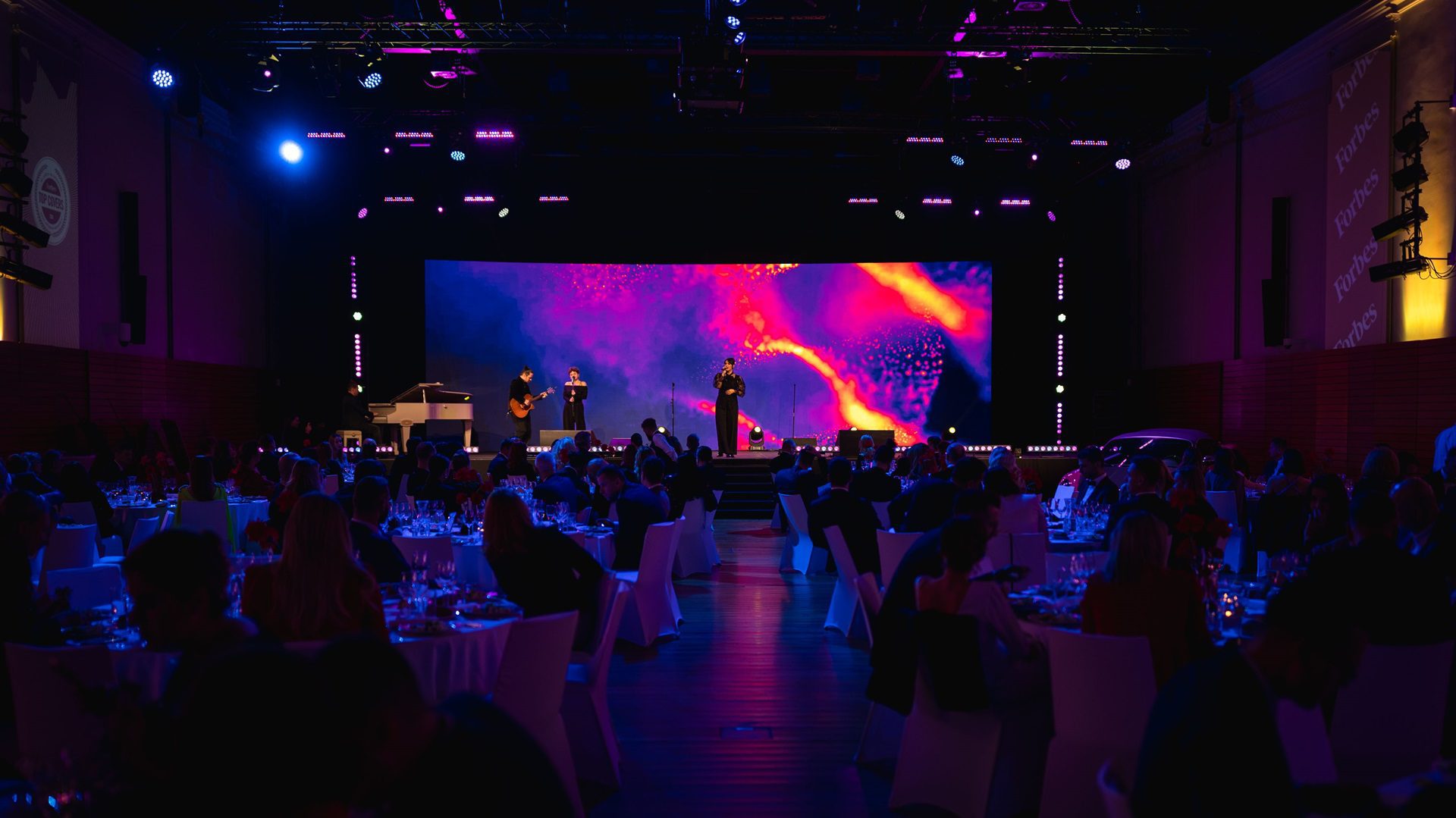 Ľudia v hľadisku sledujú predstavenie na javisku.