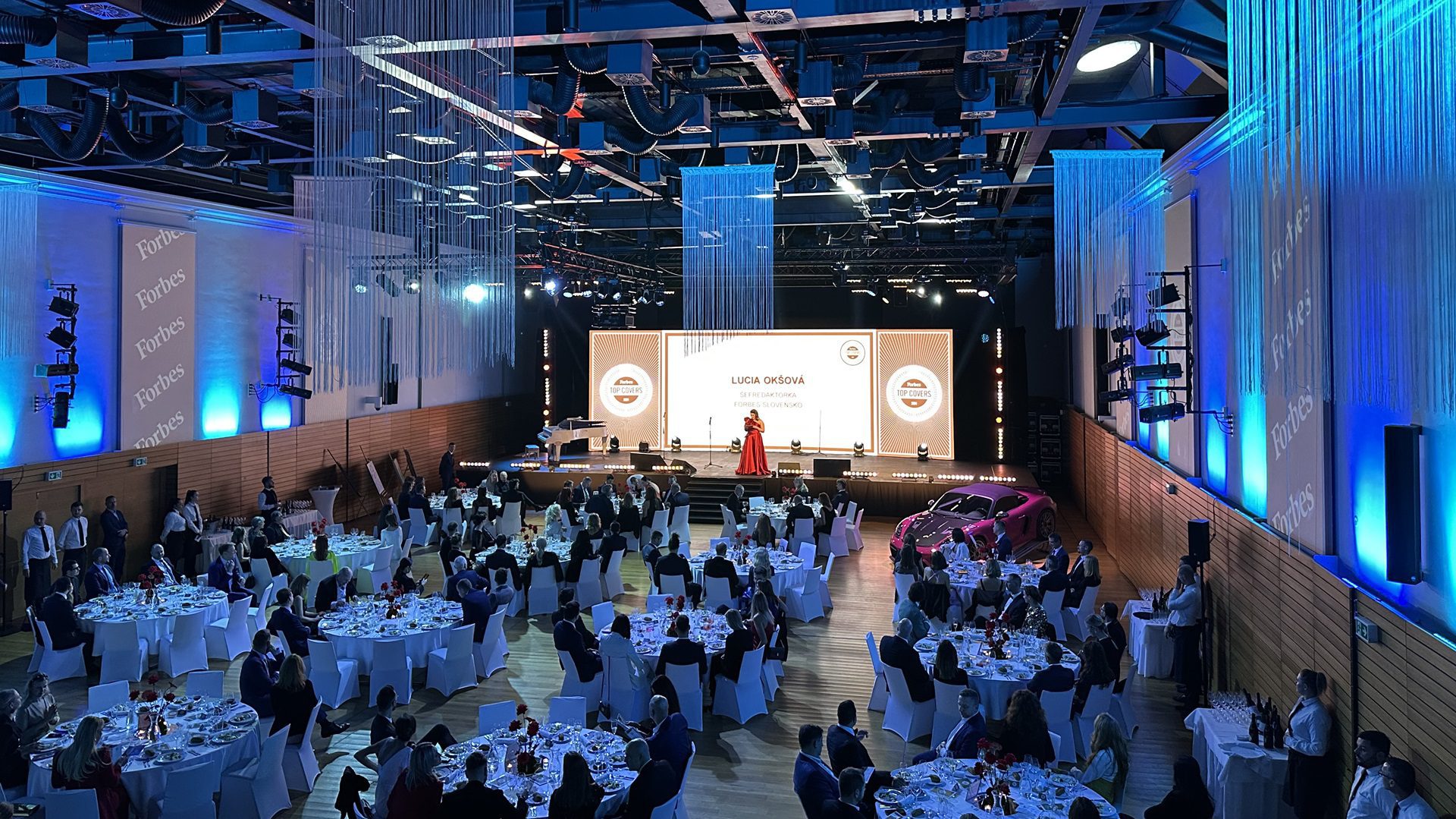 Veľká sála s ľuďmi na podujatí večer.