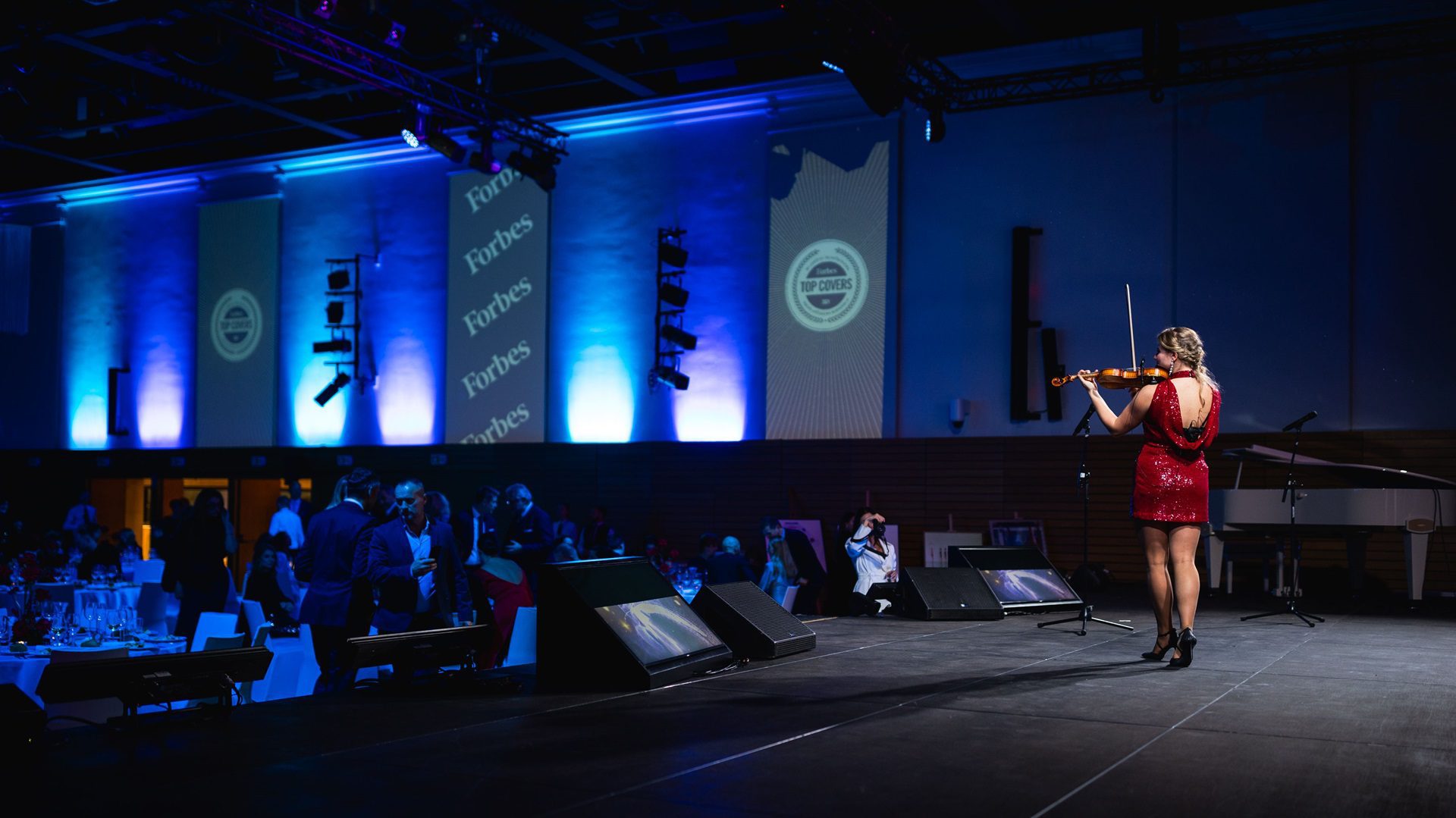 Žena hrá na husliach na pódiu.