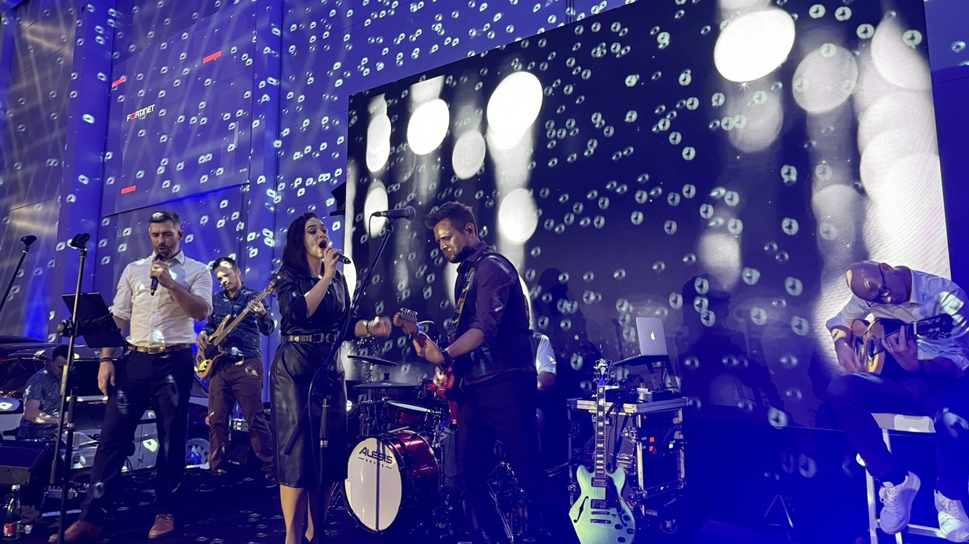 Živá hudobná skupina vystupuje na pódiu.