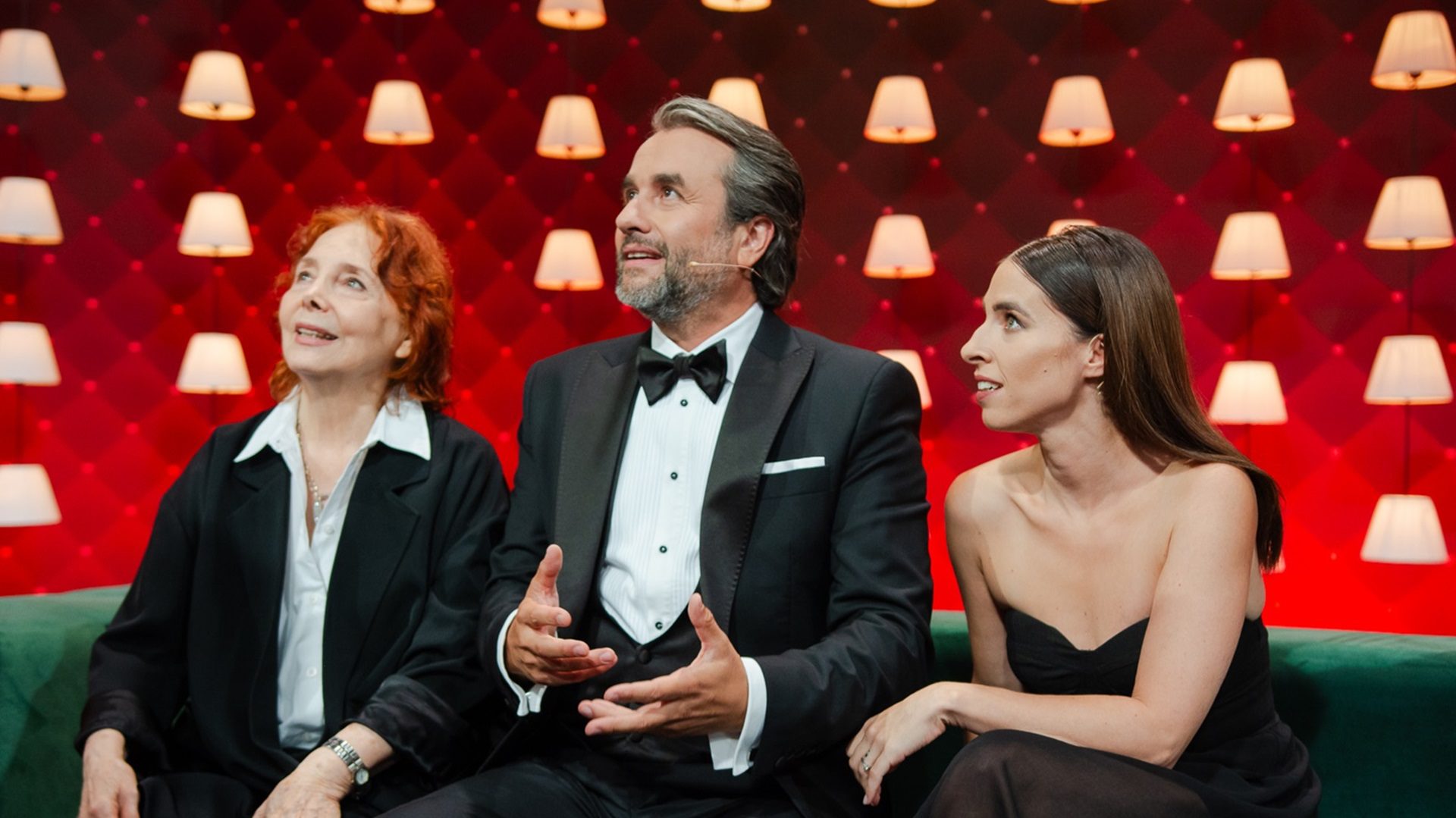 Drei Personen in einer eleganten Umgebung auf einer Party.