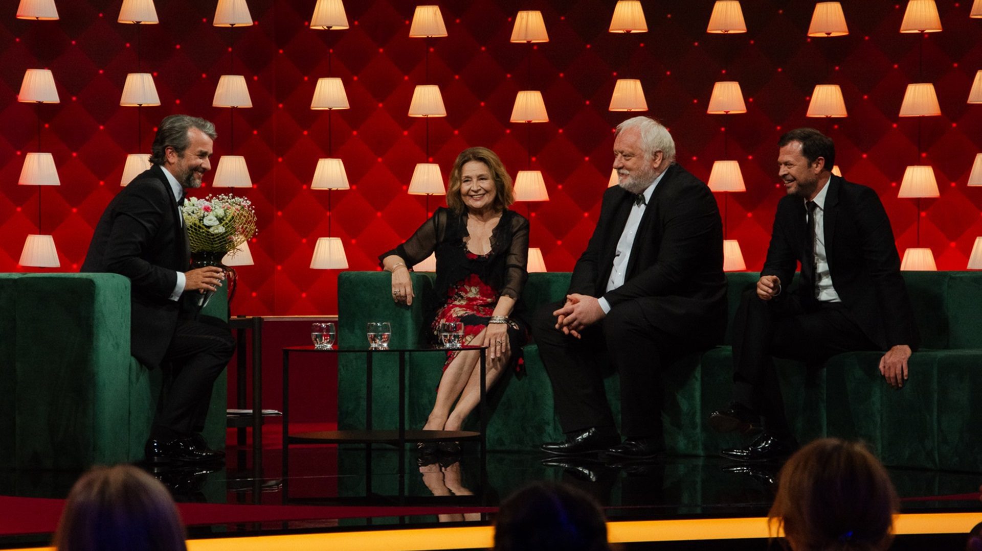 Menschen, die während einer Fernsehsendung auf der Bühne sitzen.