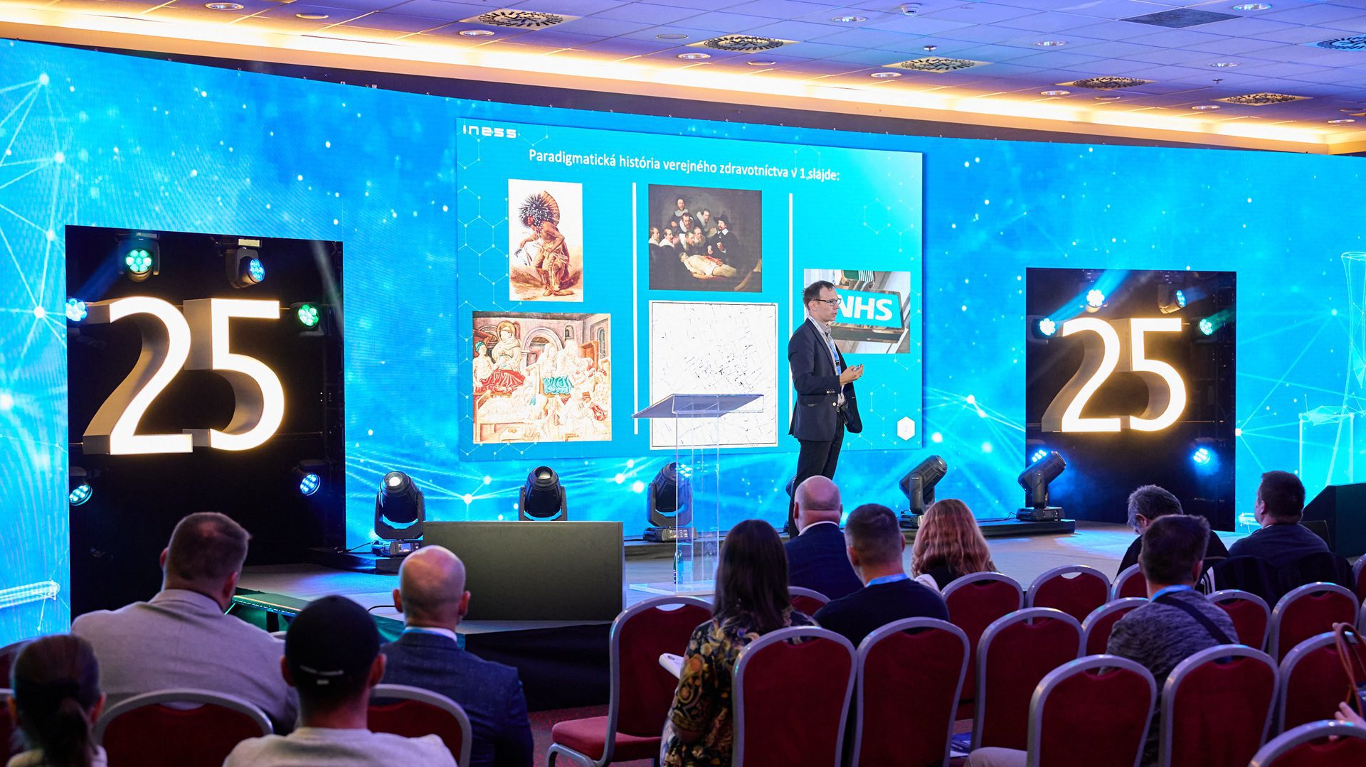 Osoba prednáša na konferencii pred publikom.