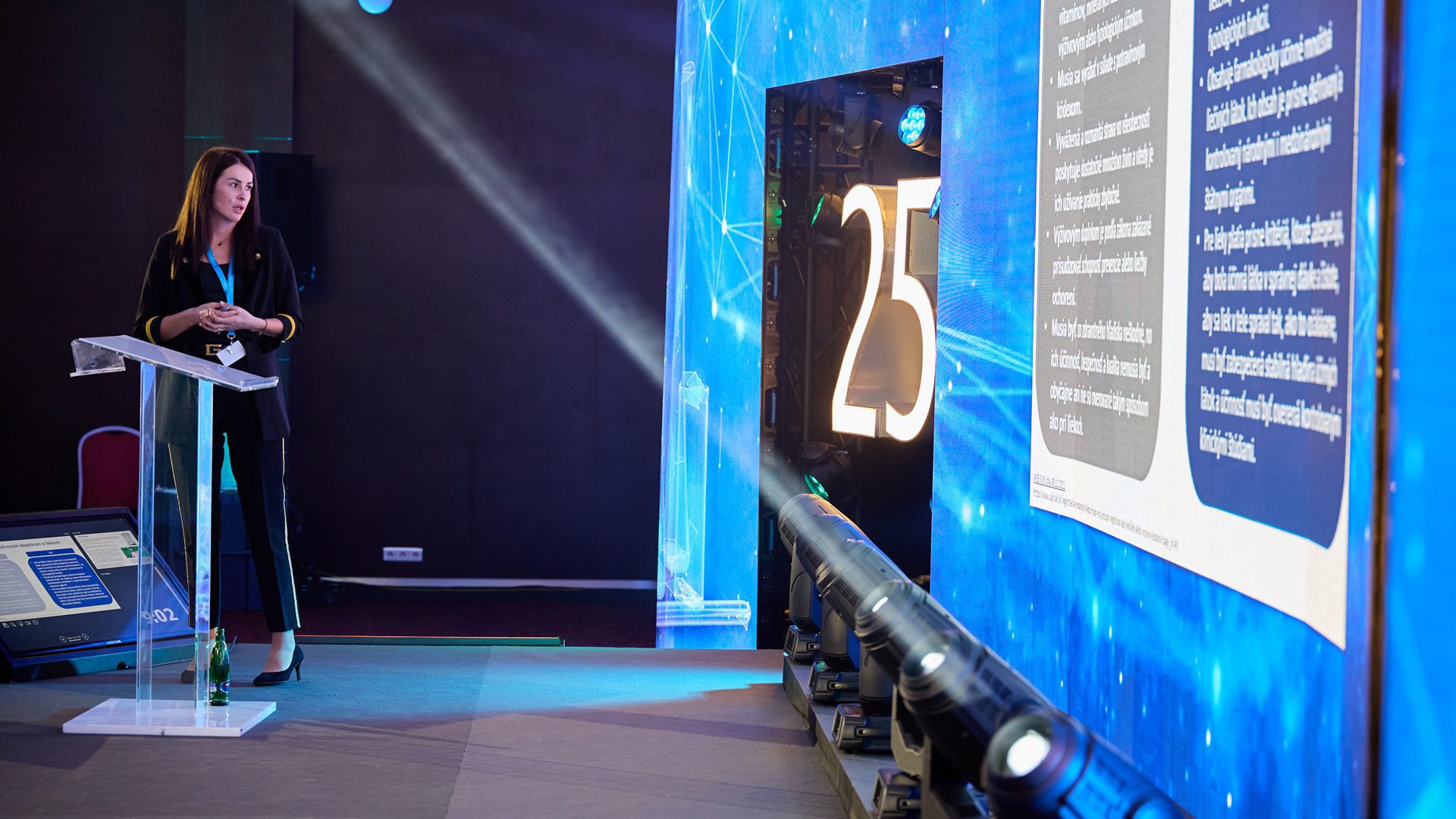 Žena prezentuje na konferencii s osvetlením a monitorom