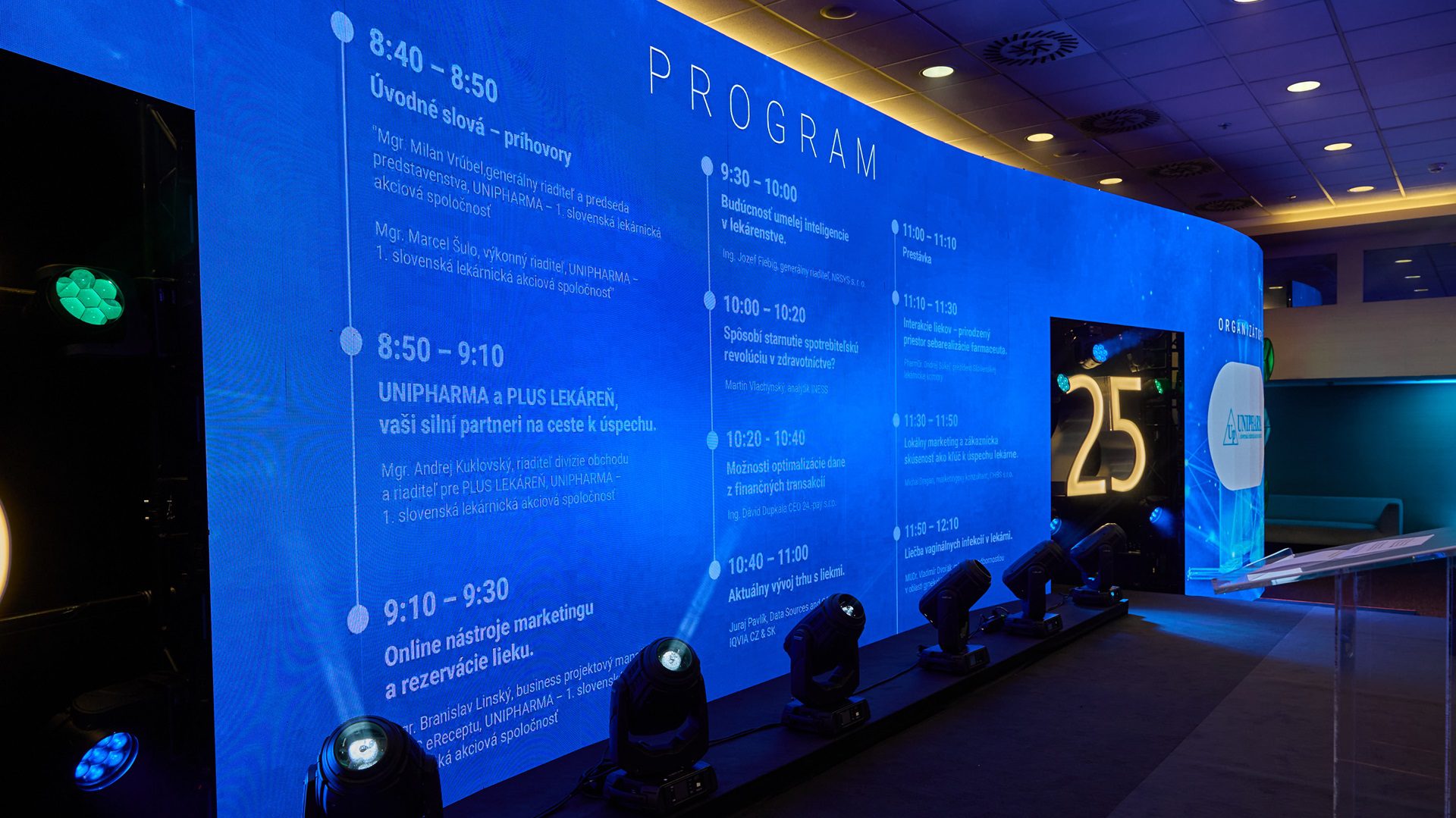 Program podujatia na modrej svetelnej stene