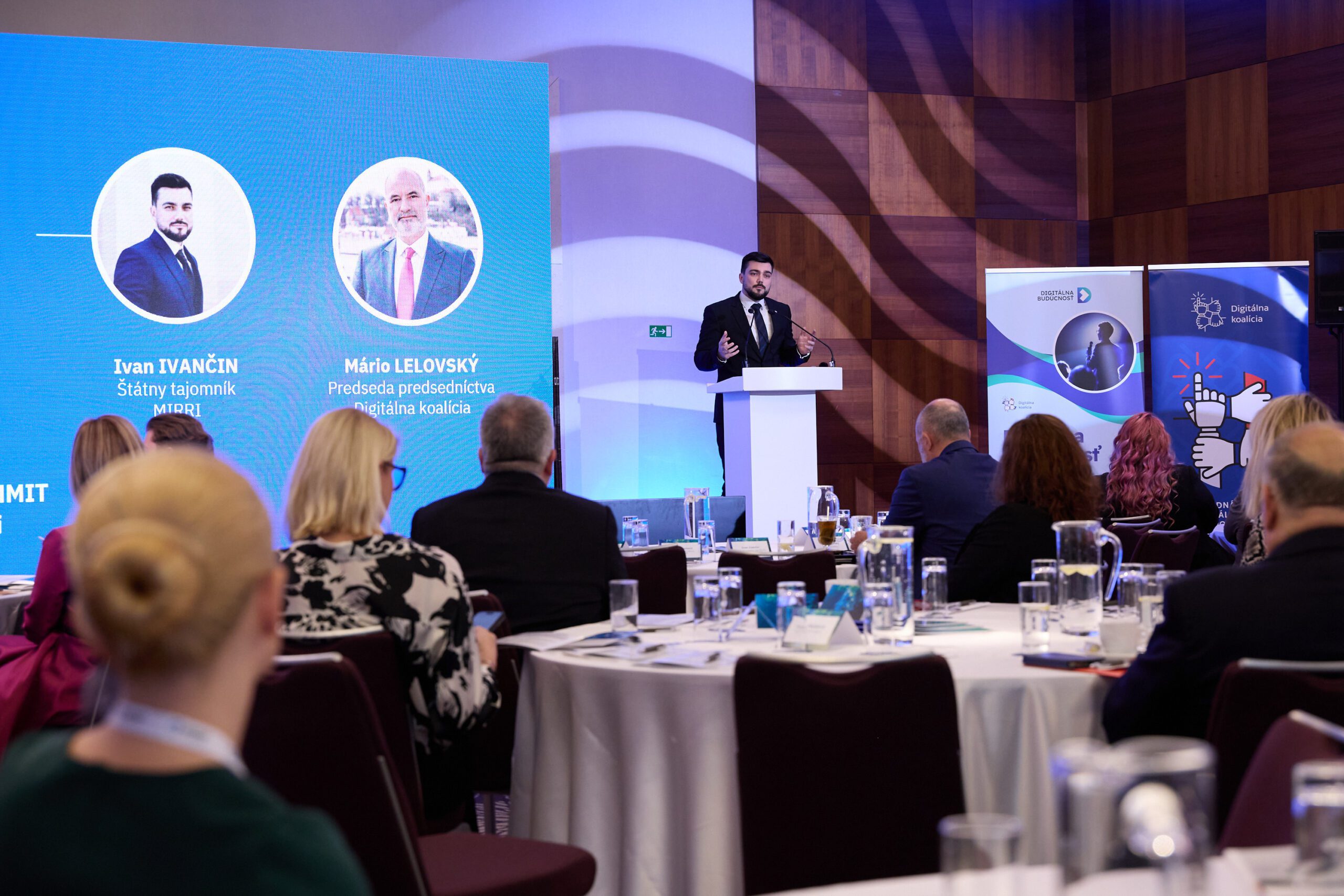 Ein Mann im Anzug steht hinter einem Rednerpult und spricht zu den Zuhörern auf dem Digitalen Gipfel.