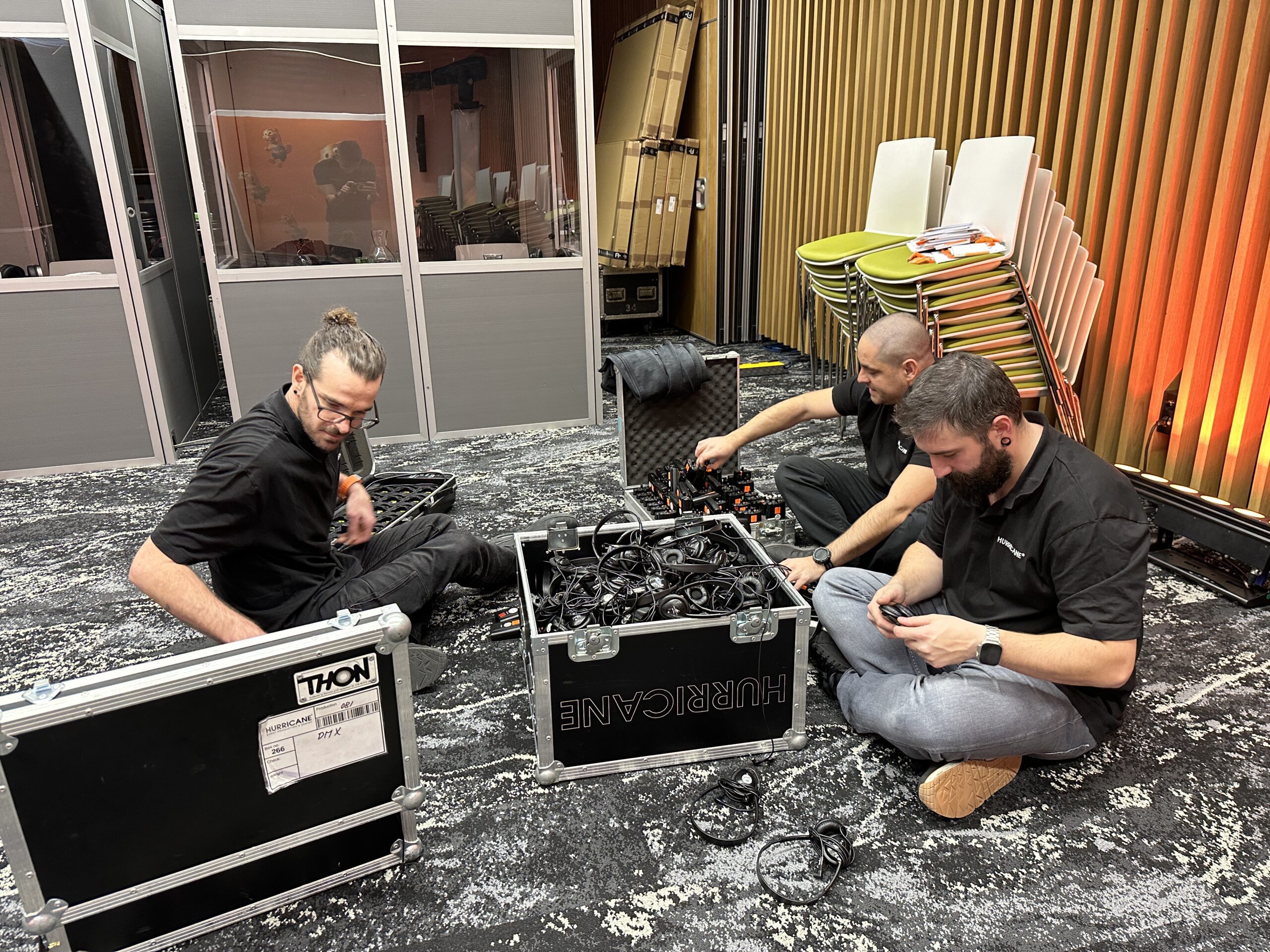 Produkčný tím Hurricane pripravuje kabeláž a techniku v zákulisí OBI eventu.