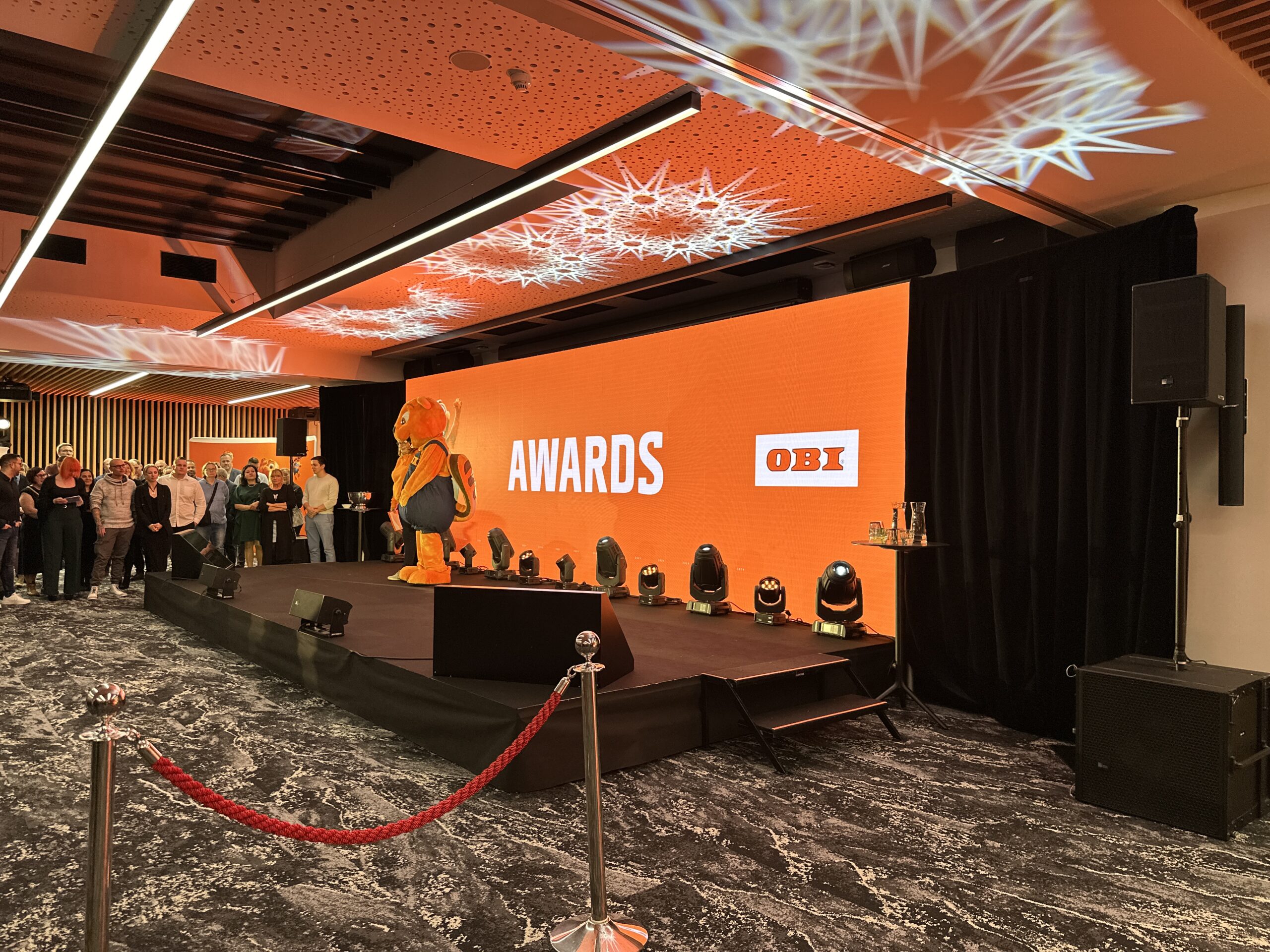 Pódium na OBI evente so svetelnými efektmi Gloshine a LED obrazovkou.