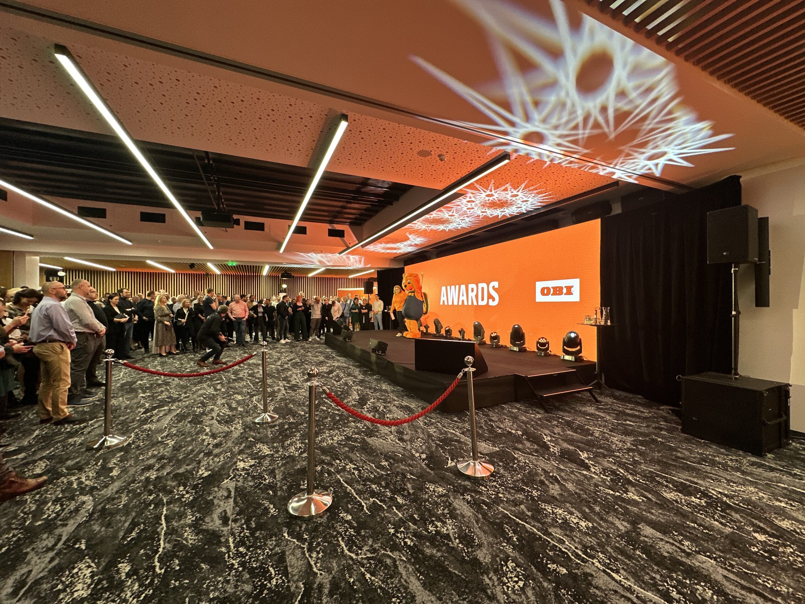 Pódium na OBI evente so svetelnými efektmi Gloshine a LED obrazovkou.