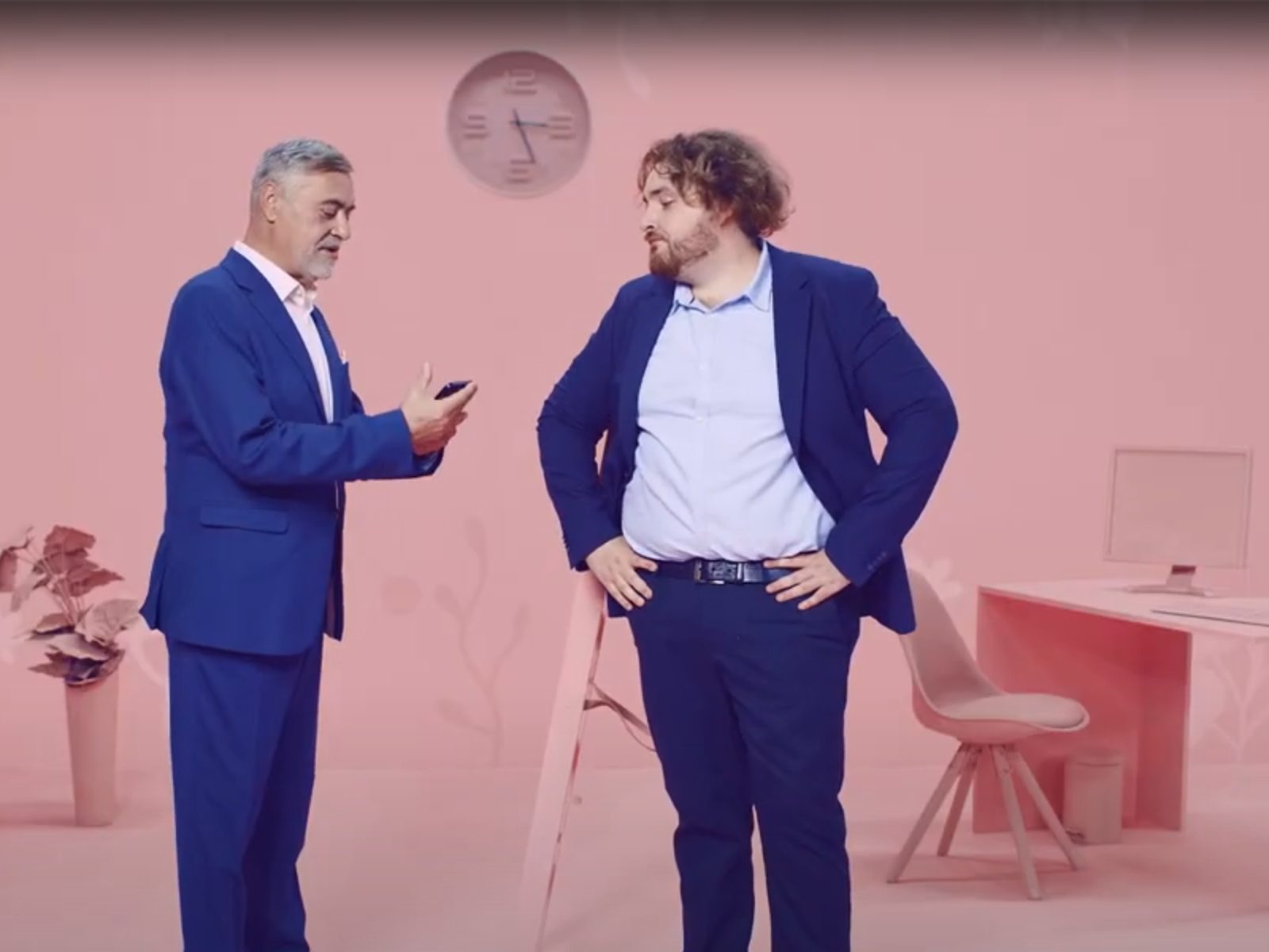 Dvaja muži v modrých oblekoch diskutujú spolu