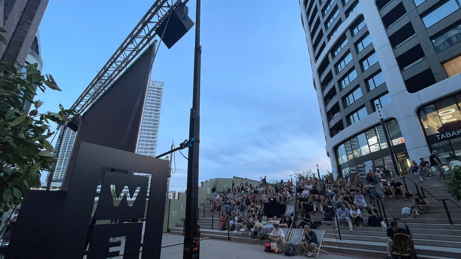 Eine Versammlung von Menschen auf den Stufen einer modernen Stadt.