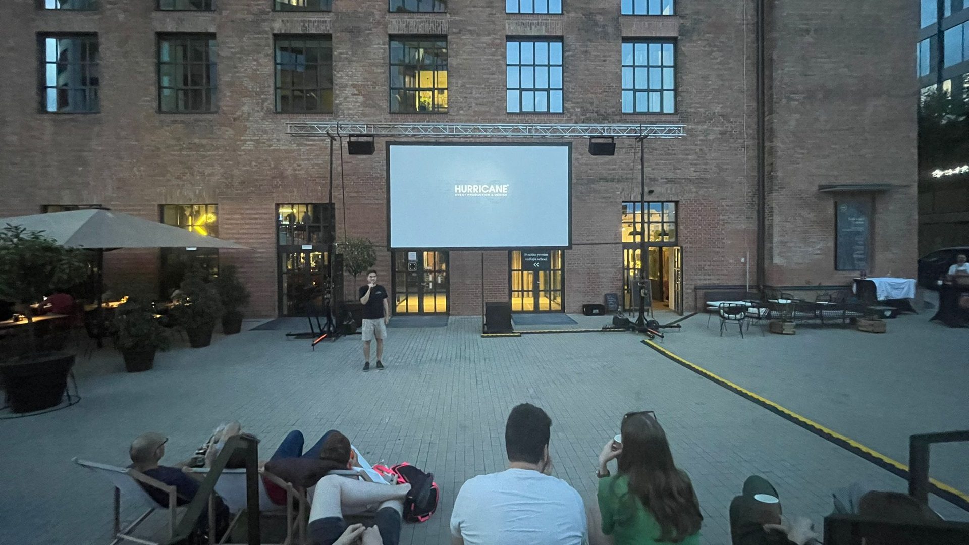 Menschen sehen einen Film auf einer Leinwand im Freien