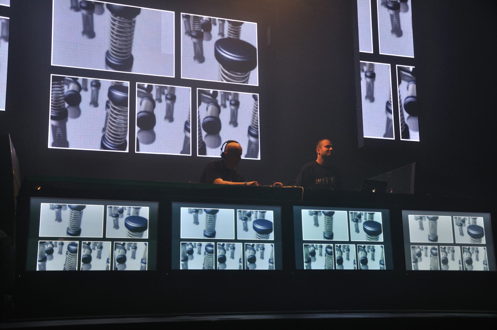 Zwei DJs auf der Bühne mit visuellen Darstellungen auf den Bildschirmen