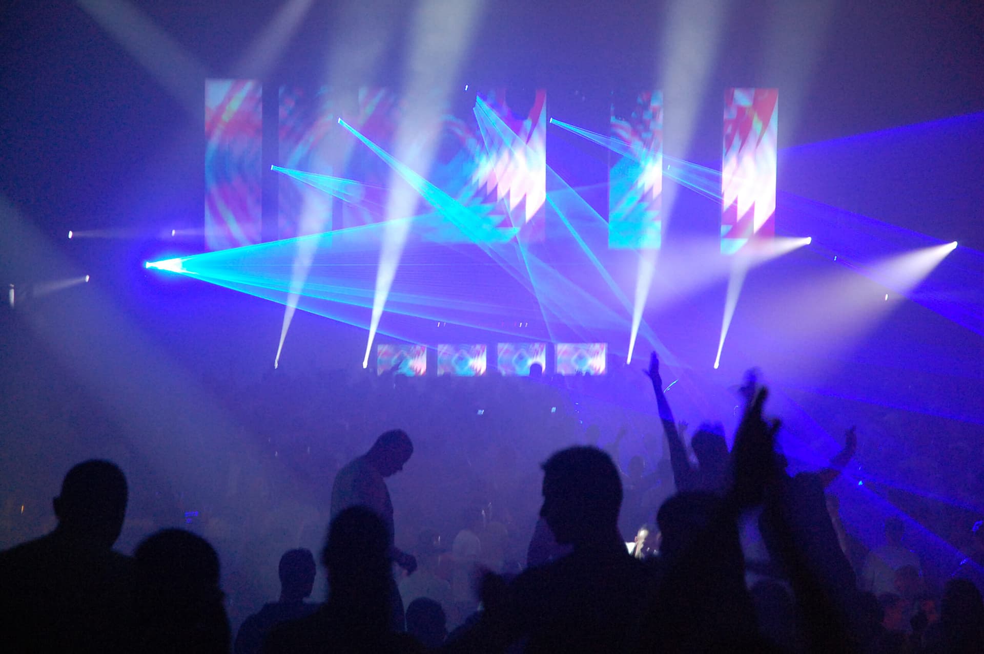 Konzert mit Lasershow, Beleuchtung und Publikum.