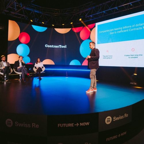 Ein Redner bei einer Konferenz auf der Bühne vor einem Publikum.