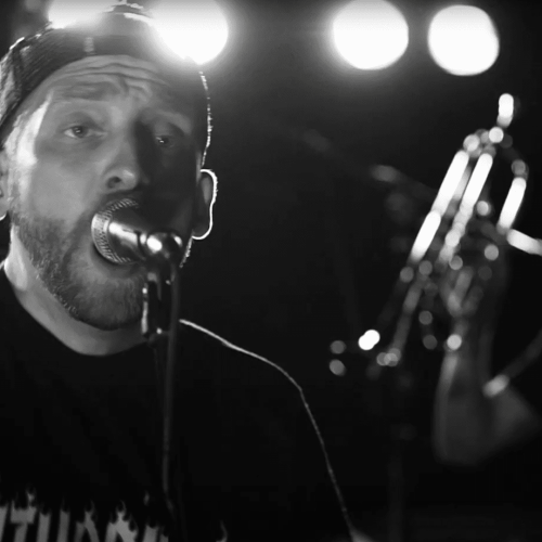 Ein Mann singt auf der Bühne mit einem Mikrofon.