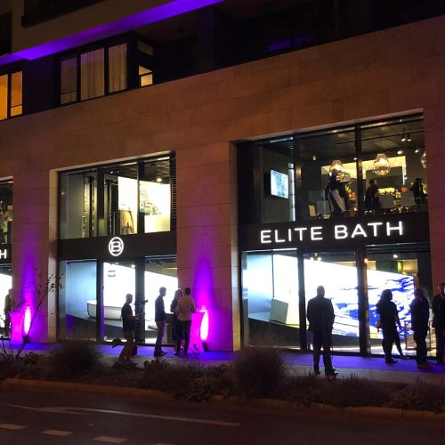Das Gebäude des Elitebads ist nachts mit violetten Lichtern beleuchtet.
