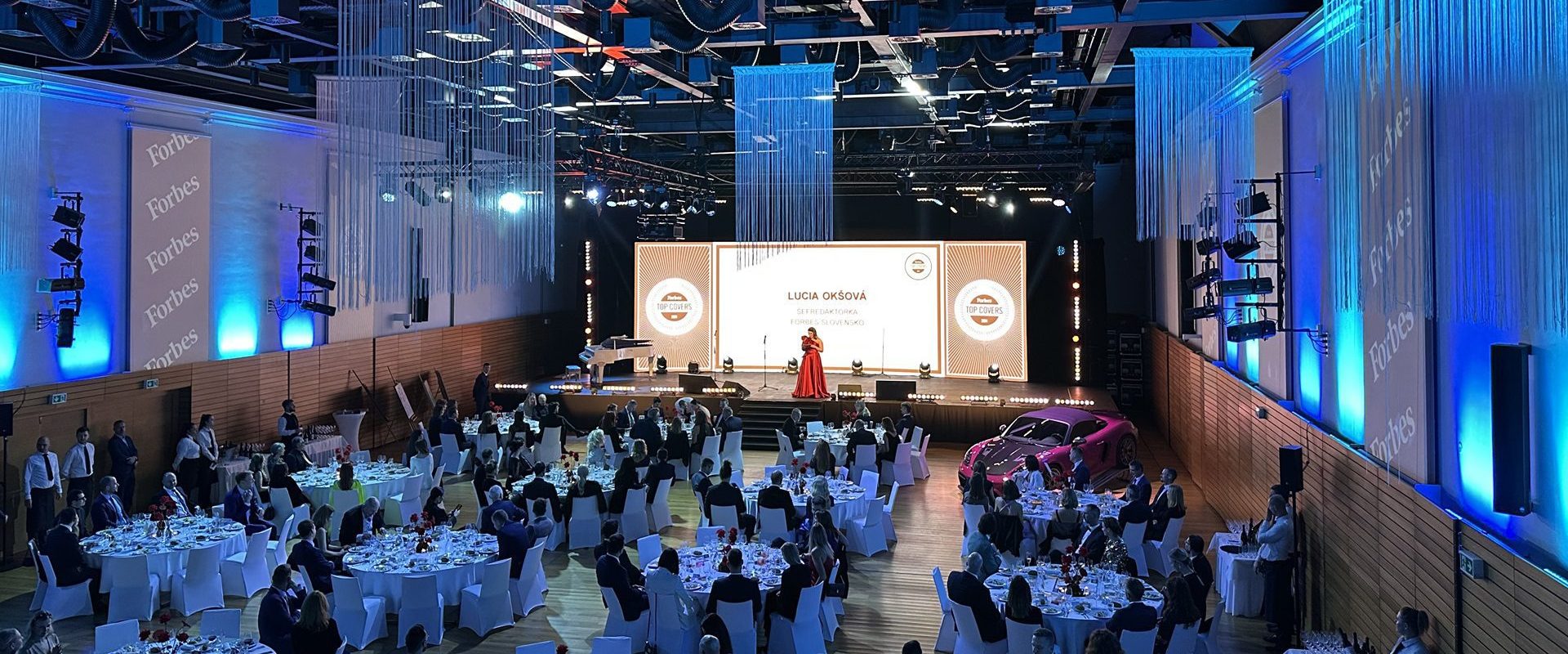 Veľká sála s ľuďmi na podujatí večer.