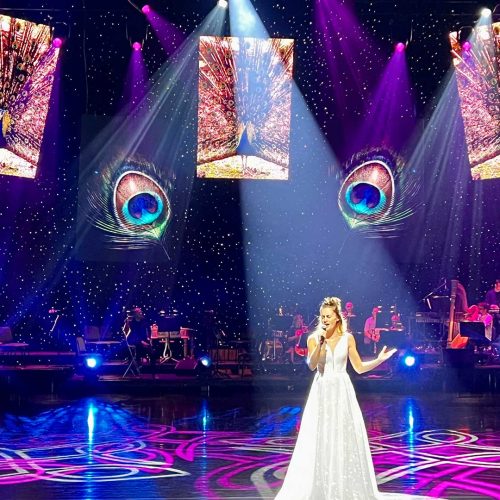 Sängerin auf der Bühne mit farbiger Beleuchtung.